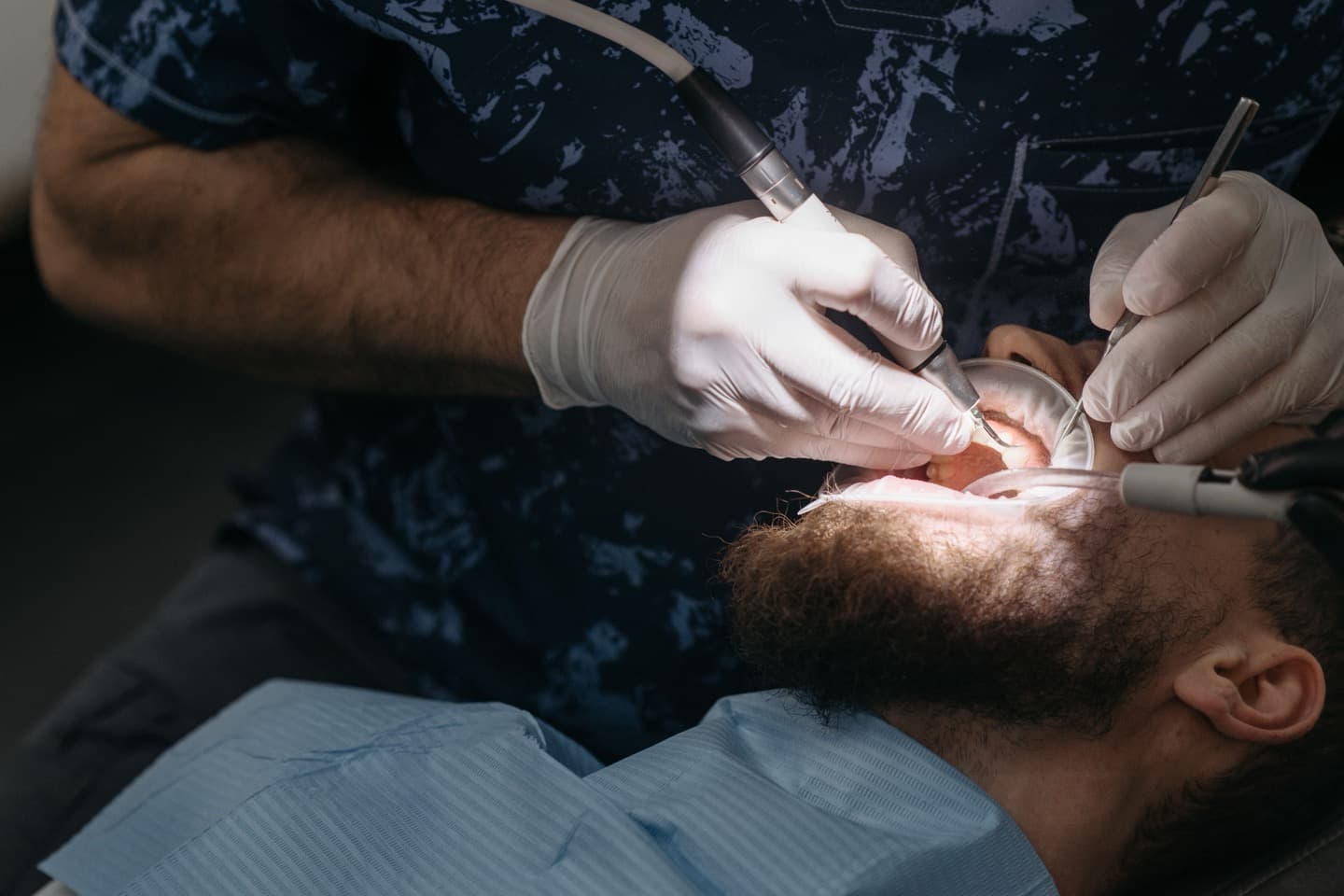 A dentist examining a patient's mouth closely during an appointment
