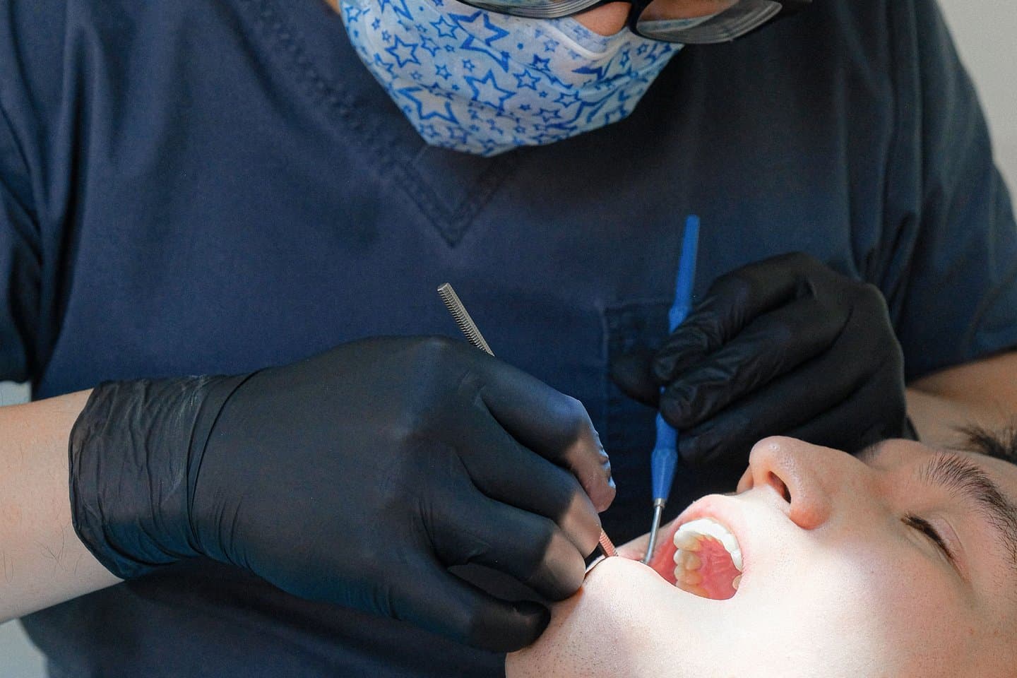 A dentist examining a patient's gums with a dental instrument