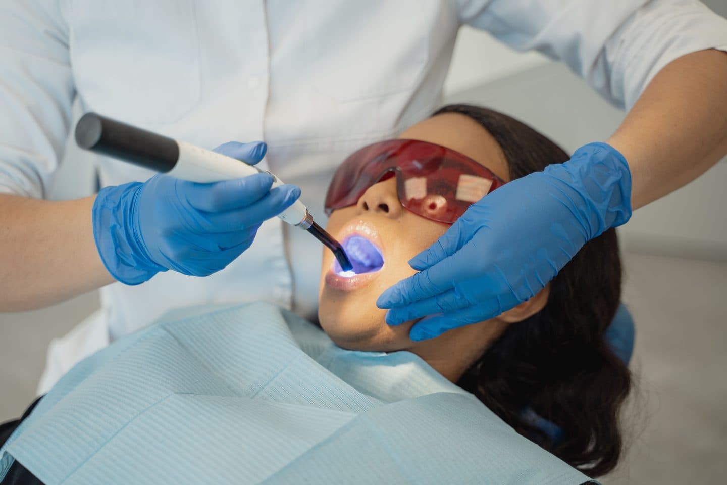 A dentist applying a curing light to a patient's tooth