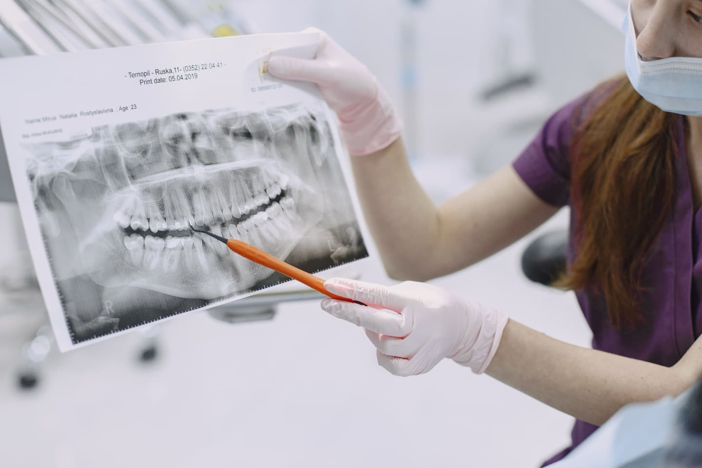 A dentist showing a patient a digital X-ray image while explaining the exam findings during a consultation